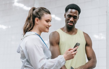 A girl showing a man something on her smartphone. 
