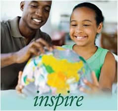 A father looking at a globe with his daughter.